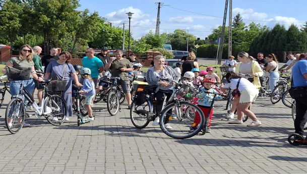 Chłopiec na rowerze z kaskiem na głowie. Szeroko się uśmiecha.